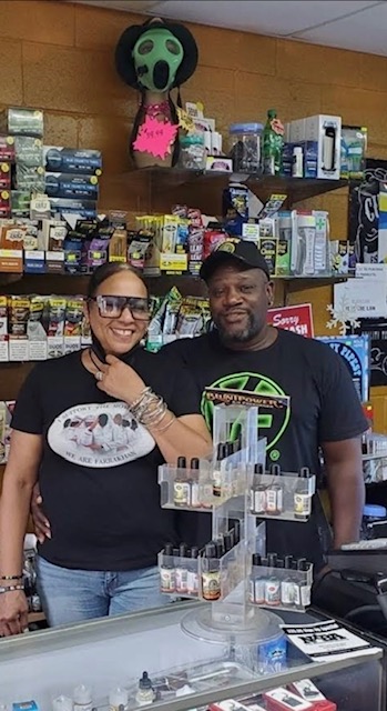 The owners of Mr. D's Smoke Shop behind the counter of their Douglasville store